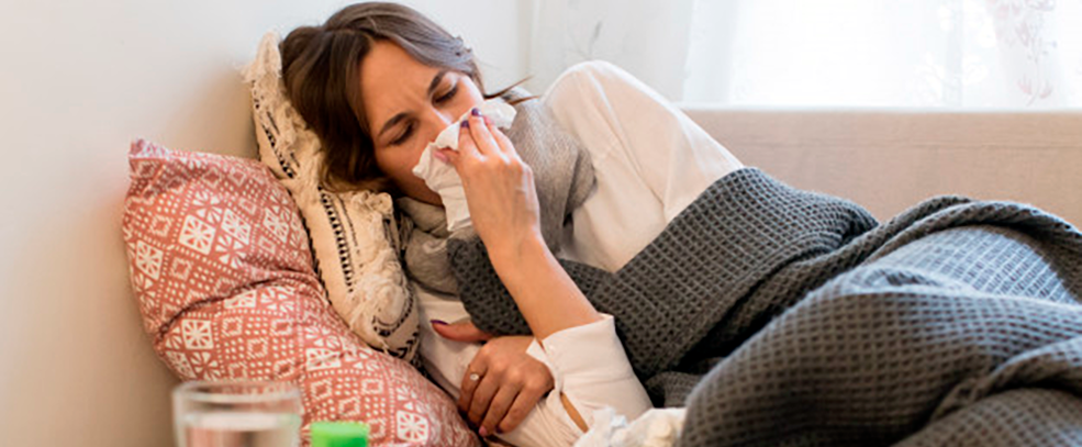 Mulher doente deitada no sofá com sintomas de gripe